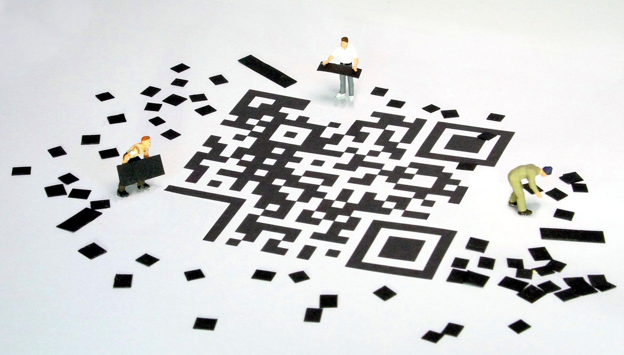 Miniature figures working around a large QR code